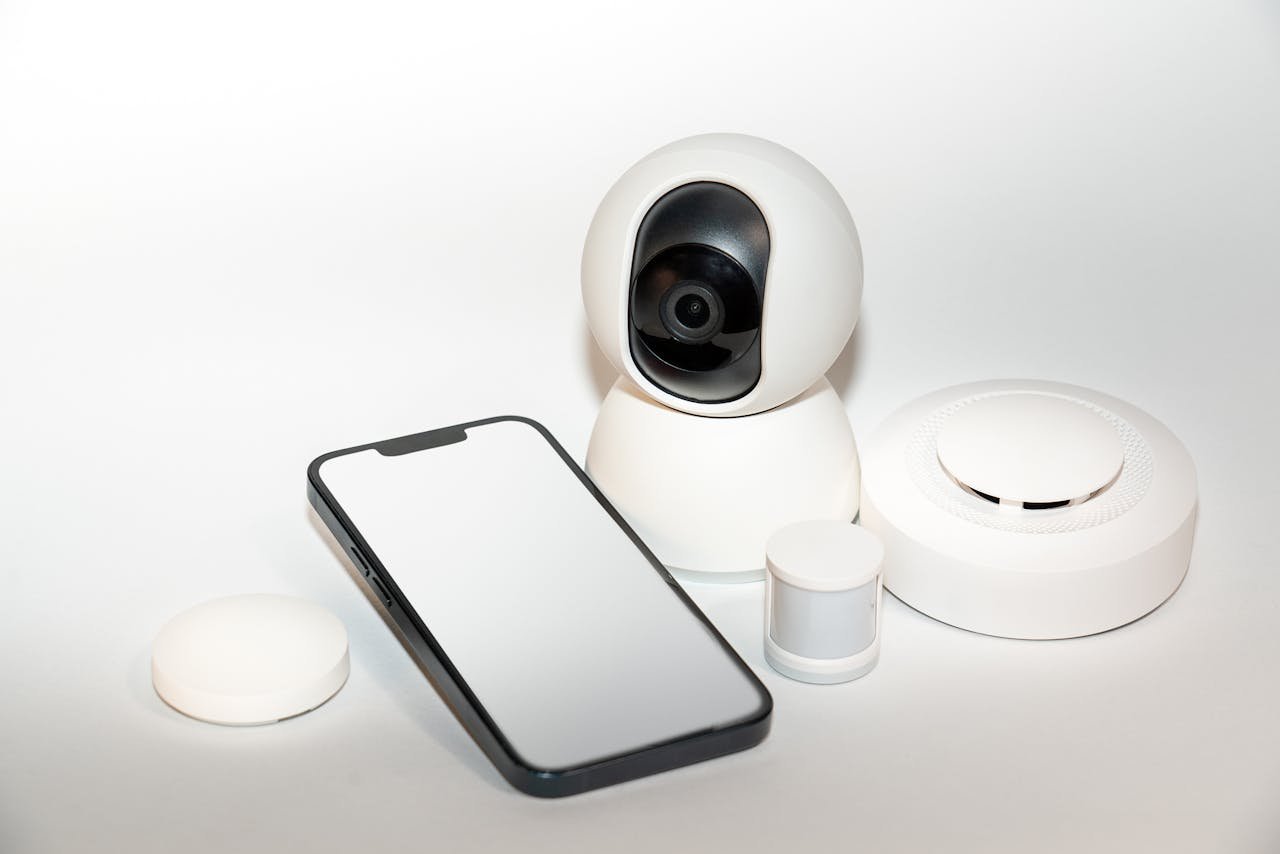 Collection of smart home security gadgets with a smartphone display.